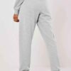 Gray lounge joggers, soft knit, close-up on textured fabric. Relaxed fit, cuffed ankles. Quality stitching visible on seams.