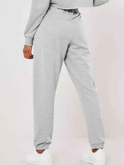 Gray lounge joggers, soft knit, close-up on textured fabric. Relaxed fit, cuffed ankles. Quality stitching visible on seams.