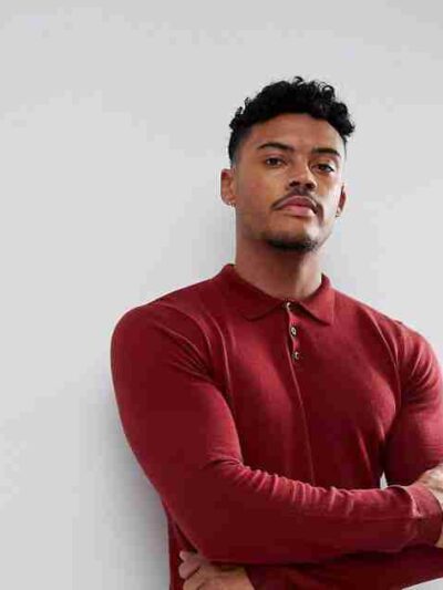Close-up: Premium polo shirt. Fine knit texture, impeccable stitching, subtle heather blue color. High-quality casual wear. -