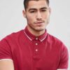 Close-up of a navy polo shirt. Fine-knit cotton with crisp collar, meticulously stitched placket, and subtle texture. Uniform