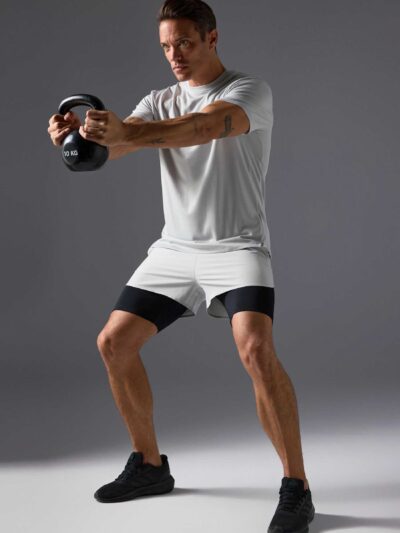 Men's two-piece short set. Textured, lightweight fabric, likely cotton blend. Matching top and shorts. Sharp, visible stitchi