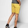 Recycled fabric shorts, close-up showing textured weave, neat stitching. Green hue hints at eco-friendly material. Sustainabl