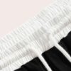 Close-up of athletic shorts, charcoal grey with a subtle textured weave. Notice reinforced stitching & built-in compression l