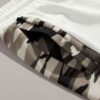 Oversized baggy streetwear shorts. Heavyweight cotton twill, visible stitching details. Neutral tone, industrial aesthetic. -