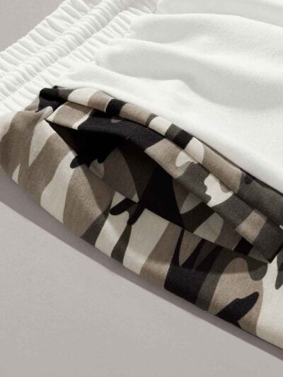 Oversized baggy streetwear shorts. Heavyweight cotton twill, visible stitching details. Neutral tone, industrial aesthetic. -