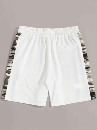Oversized baggy streetwear shorts. Heavyweight cotton twill, visible stitching details. Neutral tone, industrial aesthetic. -