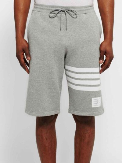 Performance athletic shorts, black with silver reflective trim. Close-up shows breathable, textured fabric and reinforced sti