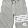 Performance athletic shorts, black with silver reflective trim. Close-up shows breathable, textured fabric and reinforced sti