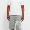 Performance athletic shorts, black with silver reflective trim. Close-up shows breathable, textured fabric and reinforced sti