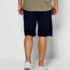 Close-up of athletic shorts fabric. Visible moisture-wicking weave, reinforced stitching. Performance garment in neutral gray