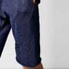 Close-up of athletic shorts fabric. Visible moisture-wicking weave, reinforced stitching. Performance garment in neutral gray