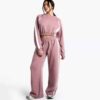 Women's two-piece tracksuit set, likely fleece or terry knit. Custom neck label detail. Athleisure wear, comfy fit, relaxed s