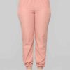 Long, relaxed-fit sweatsuit set in soft heather gray. Drawstring tie at waist, visible stitching details, comfortable knit fa