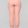Long, relaxed-fit sweatsuit set in soft heather gray. Drawstring tie at waist, visible stitching details, comfortable knit fa