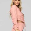 Long, relaxed-fit sweatsuit set in soft heather gray. Drawstring tie at waist, visible stitching details, comfortable knit fa