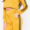 Cropped tracksuit in soft-touch knit fabric. Side stripe detail. Sporty-casual style with clean stitching, hints of vibrant c