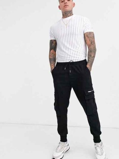 Slim-fit tee with a bold chest graphic and textured mesh stripes. Black & grey hues, visible fine stitching detail. Breathabl