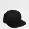Black snapback cap. Close-up reveals tight stitching, structured crown, and matte texture. Adjustable fit, flat brim, urban s
