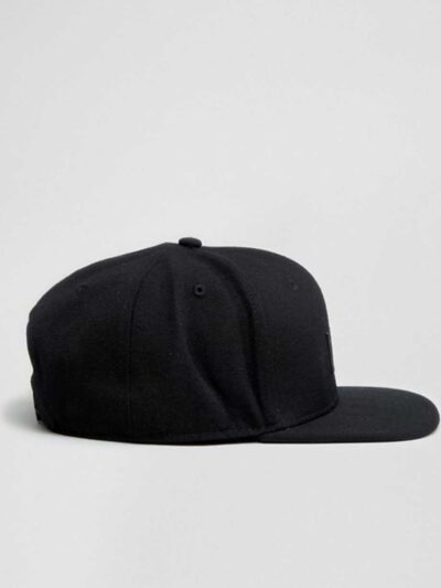 Structured canvas snapback cap. Flat brim, visible stitching detail. Adjustable back closure. Modern streetwear style. - View