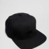 Structured canvas snapback cap. Flat brim, visible stitching detail. Adjustable back closure. Modern streetwear style. - View