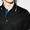 Close-up of a custom tennis polo. Fine pique knit texture, clean stitching, vibrant color, tailored fit. A sporty, refined ga