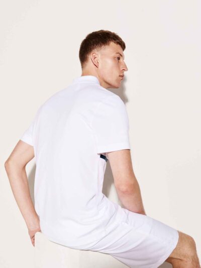 Close-up of a textured cotton polo shirt with visible breathable weave and reinforced stitching. Sportswear in a subtle shade