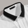 Close-up of a polo shirt featuring striped collar & cuffs, chevron pattern detail. Soft textured fabric, quality stitching ap