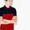 Close-up of a polo shirt with stylish color blocking and a prominent neck label. Textured fabric with visible, quality stitch