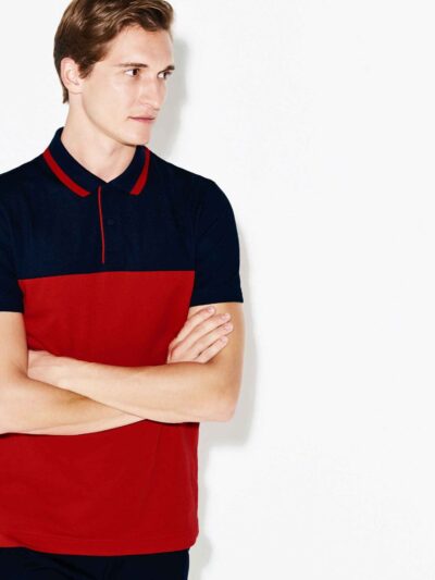 Close-up of a polo shirt with stylish color blocking and a prominent neck label. Textured fabric with visible, quality stitch