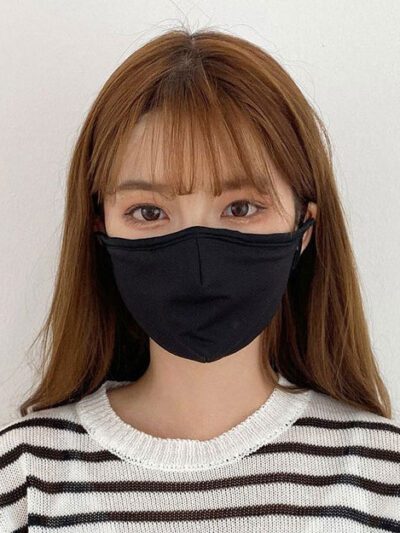 Close-up of a breathable three-layer face mask, charcoal gray color, showcasing fine stitching, adjustable ear loops, and a s