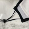 Close-up of a breathable three-layer face mask, charcoal gray color, showcasing fine stitching, adjustable ear loops, and a s