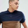 Close-up of embroidered polo shirt, fine pique knit texture. Royal blue fabric, crisp white logo stitching. Professional staf