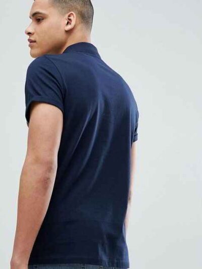 Close-up of embroidered polo shirt, fine pique knit texture. Royal blue fabric, crisp white logo stitching. Professional staf