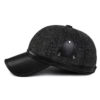Ear flap baseball cap: PU leather visor, woolen striped panels. Folded ear flaps show stitching. Unisex style, warm fabric. -