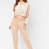 Close-up of a luxurious velour cropped tracksuit. Soft texture, visible stitching, and subtle branding details. A stylish, co
