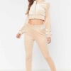Close-up of a luxurious velour cropped tracksuit. Soft texture, visible stitching, and subtle branding details. A stylish, co