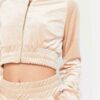 Close-up of a luxurious velour cropped tracksuit. Soft texture, visible stitching, and subtle branding details. A stylish, co