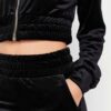 Close-up of a luxurious velour cropped tracksuit. Soft texture, visible stitching, and subtle branding details. A stylish, co