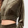 Close-up of a luxurious velour cropped tracksuit. Soft texture, visible stitching, and subtle branding details. A stylish, co