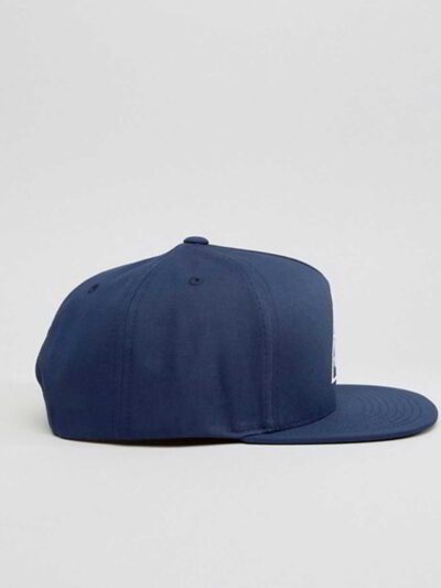 Close-up of a vintage corduroy baseball cap. Notice the soft, ridged texture, embroidered logo, and durable stitching. A casu