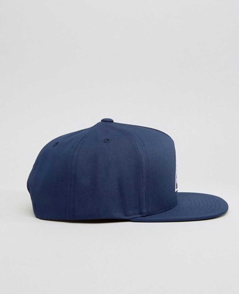 Close-up of a vintage corduroy baseball cap. Notice the soft, ridged texture, embroidered logo, and durable stitching. A casu