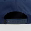 Close-up of a vintage corduroy baseball cap. Notice the soft, ridged texture, embroidered logo, and durable stitching. A casu