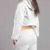 White cotton girls' sweatsuit. Soft, looped interior. Ribbed cuffs & hem. Comfortable fit, visible stitching detail. Sporty &