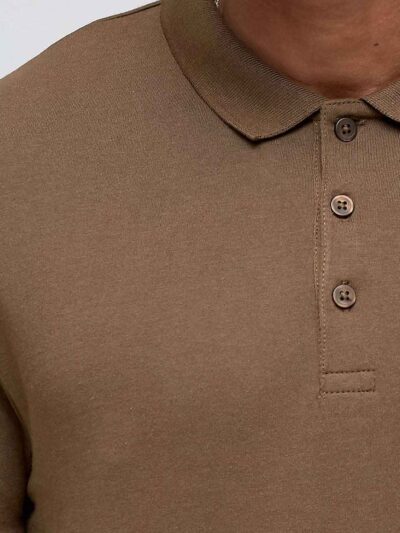 Close-up of a textured polo shirt. Fine pique knit, reinforced stitching, vibrant color hints. Customizable with your logo. -