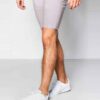 Close-up of athletic shorts. Smooth, flexible fabric, reinforced stitching. Deep black with subtle reflective accents. Workou