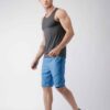 Blue quick-dry swim trunks with white drawstring. Fine stitching details visible. Lightweight, textured fabric. Beachwear. -