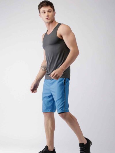 Blue quick-dry swim trunks with white drawstring. Fine stitching details visible. Lightweight, textured fabric. Beachwear. -