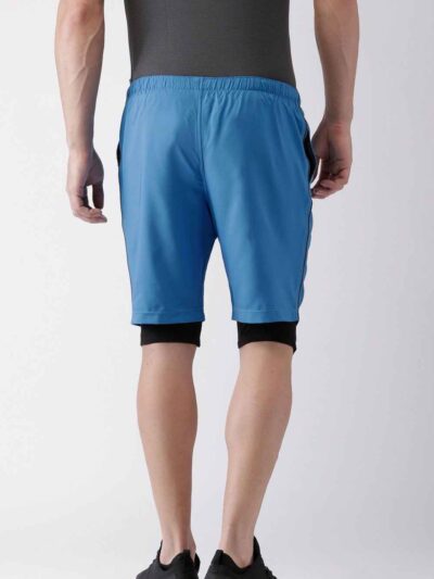 Blue quick-dry swim trunks with white drawstring. Fine stitching details visible. Lightweight, textured fabric. Beachwear. -