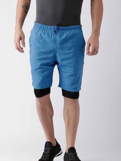 Blue quick-dry swim trunks with white drawstring. Fine stitching details visible. Lightweight, textured fabric. Beachwear. -