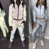 Reflective tracksuit set: shimmering silver accents on durable black fabric. Visible zipper tracks, tailored fit, quality sti